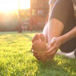 An athlete with foot pain sitting on grass