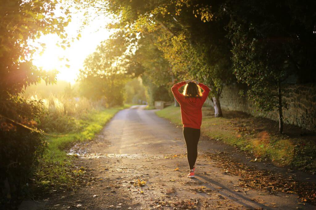 A jogger walking along a sunny country road